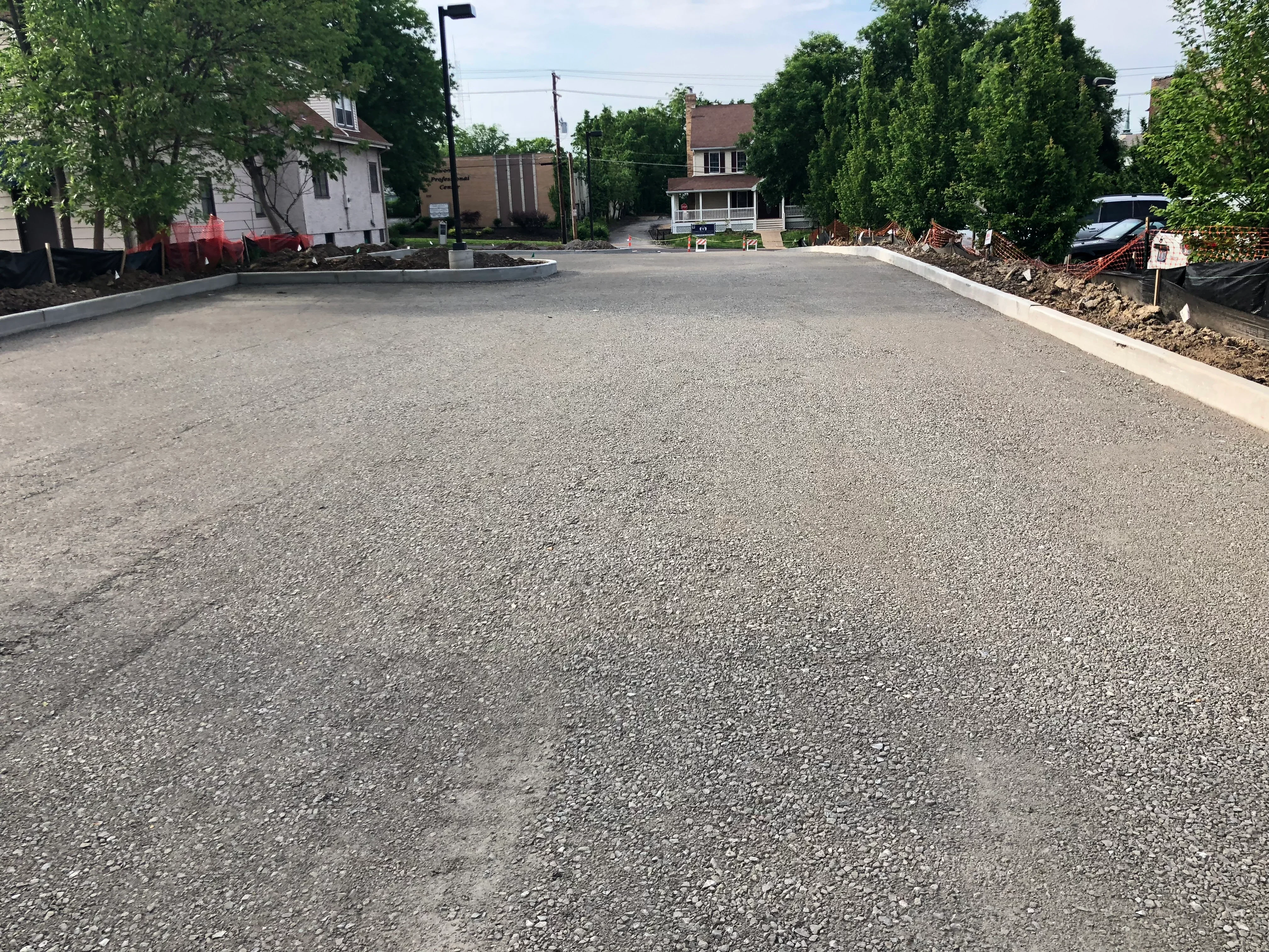 Graded and compacted residential lot with concrete curbing and cleared perimeter